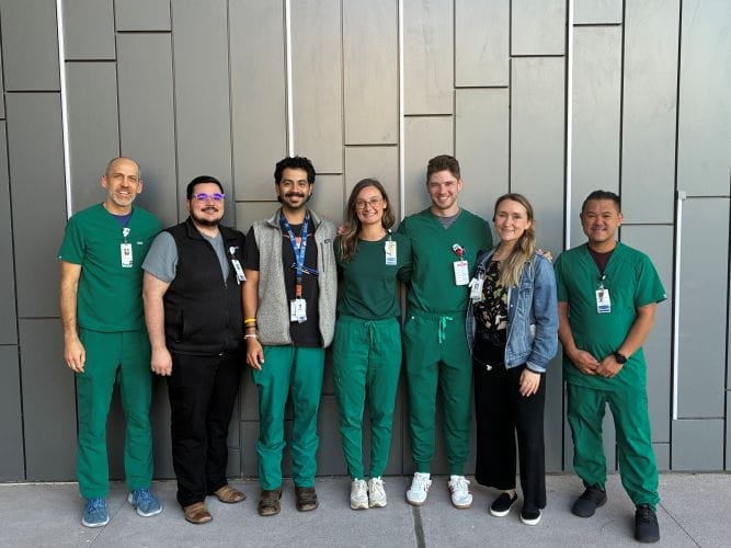 Pharmacy residents standing in front of gray wall
