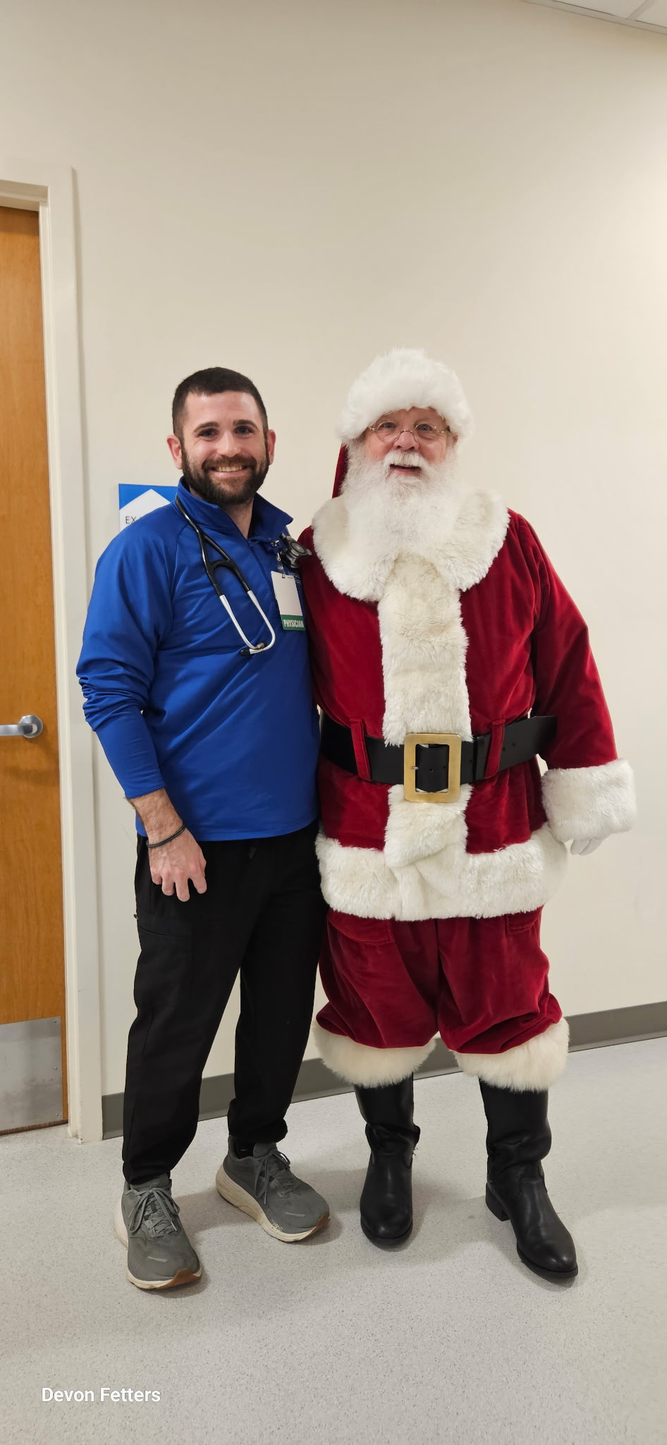 Dr. Devon Fetters standing next to one of our patients, Santa Claus!